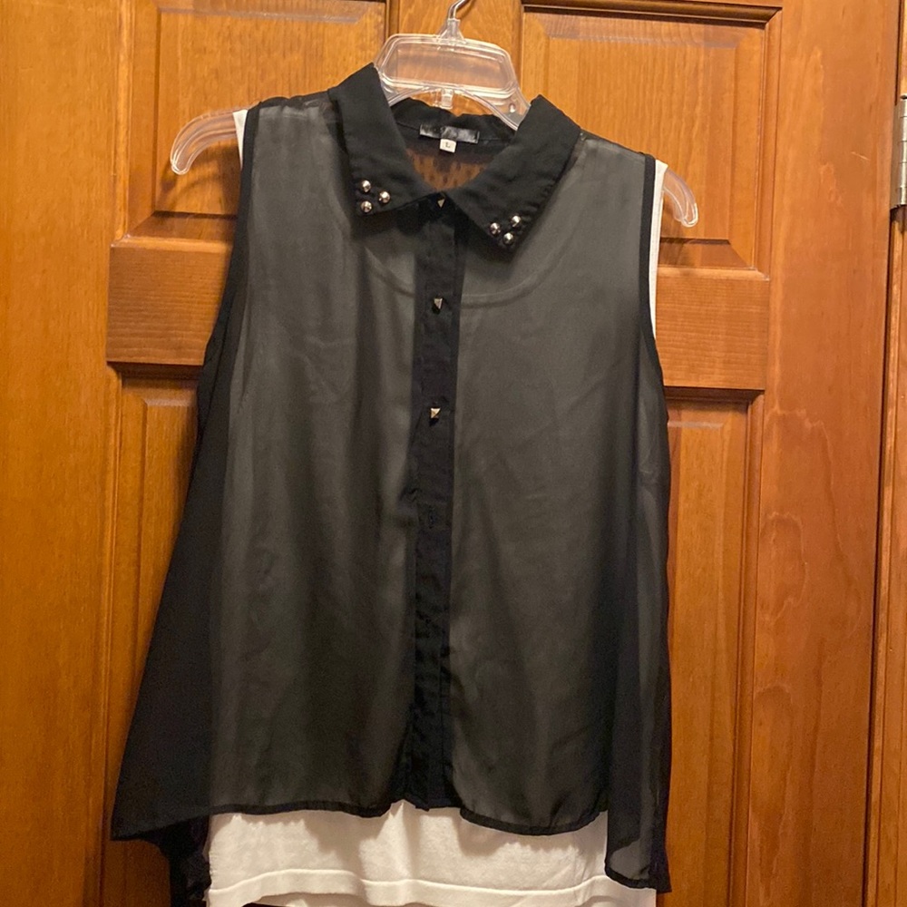 Sheer black sleeveless blouse with studded buttons.